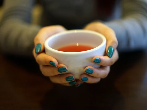 Esta imagen te muestra las manos de una mujer sosteniendo una taza donde hay una infusión. (Foto: Oleksandr Pyrohov / Pixabay)
